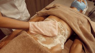 masseur-rubbing-cream-on-stomach-of-slim-woman-DNX7CDX.jpg